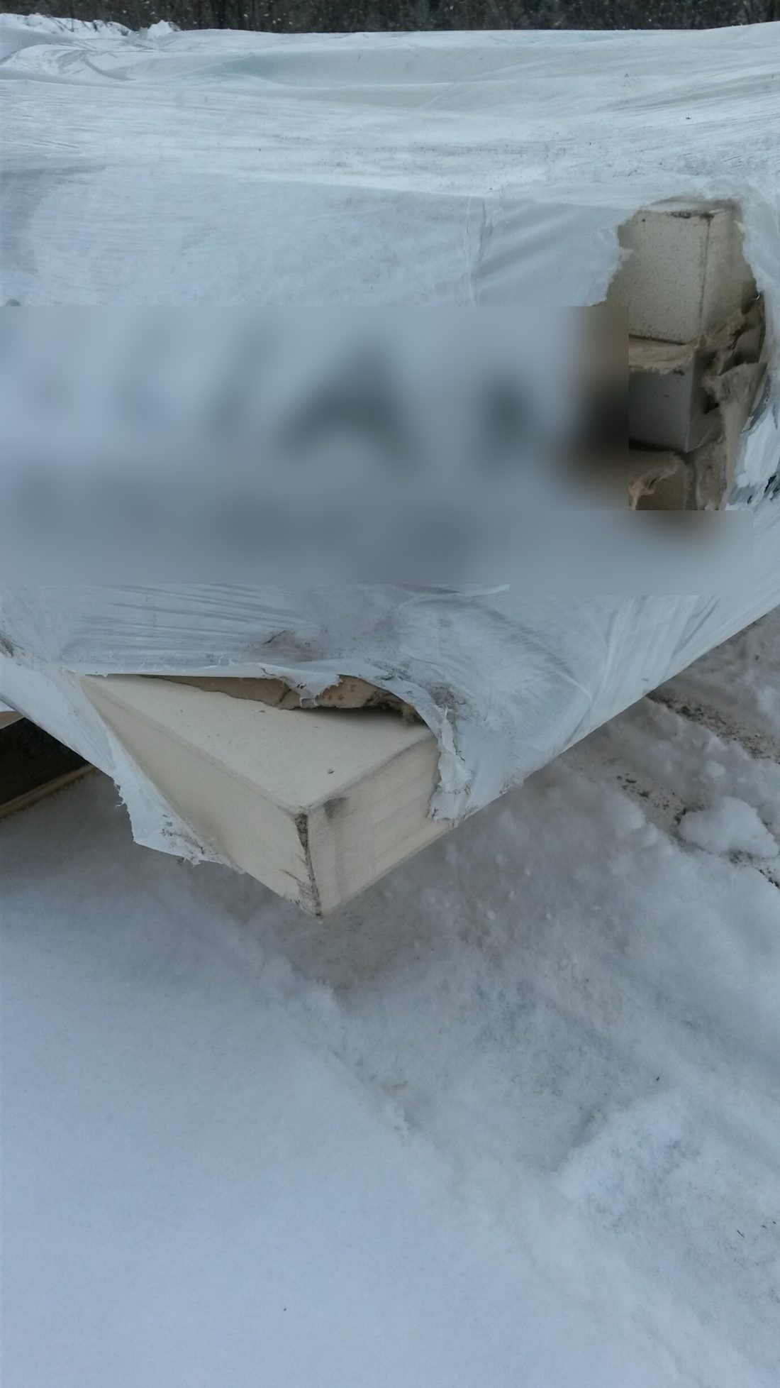 Pallet of freight with torn stretch wrap exposing damaged product corners