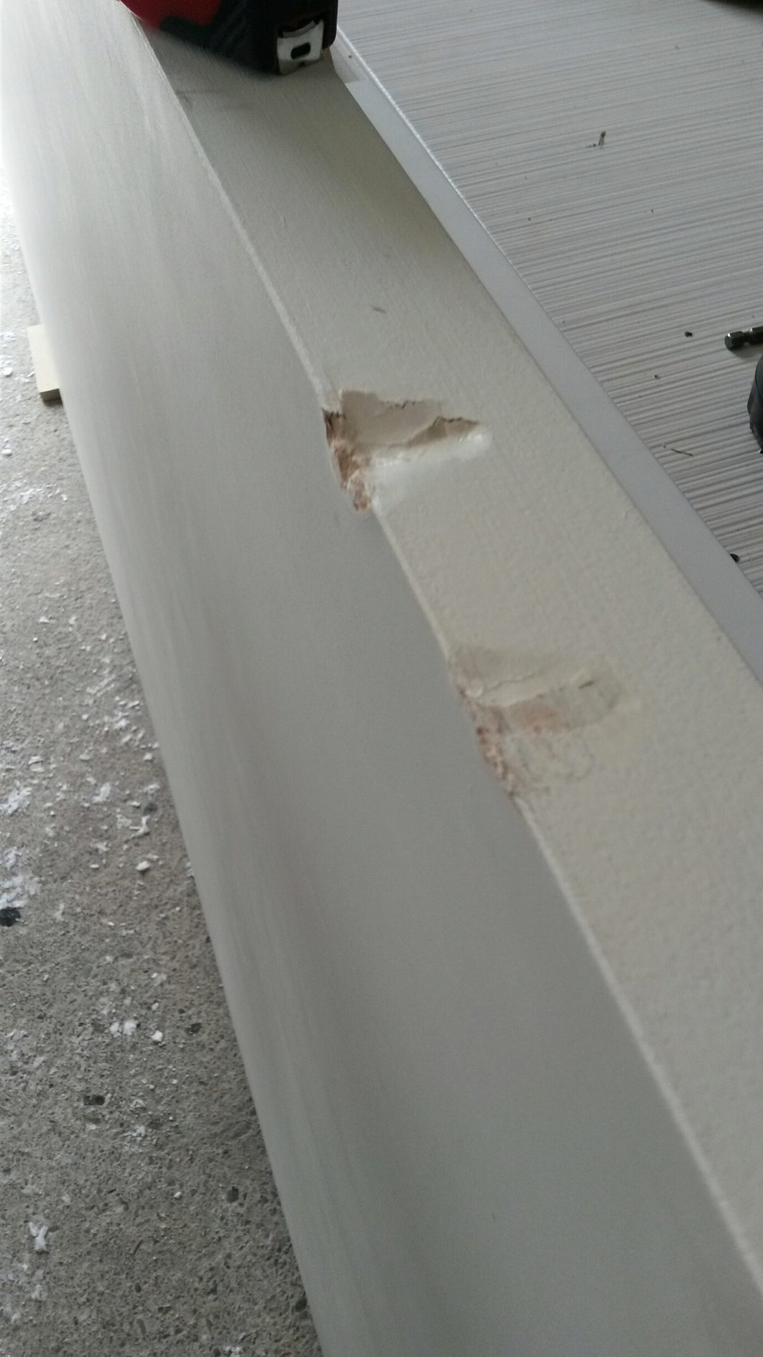 Chipped and gouged edge of a panel damaged during shipping
